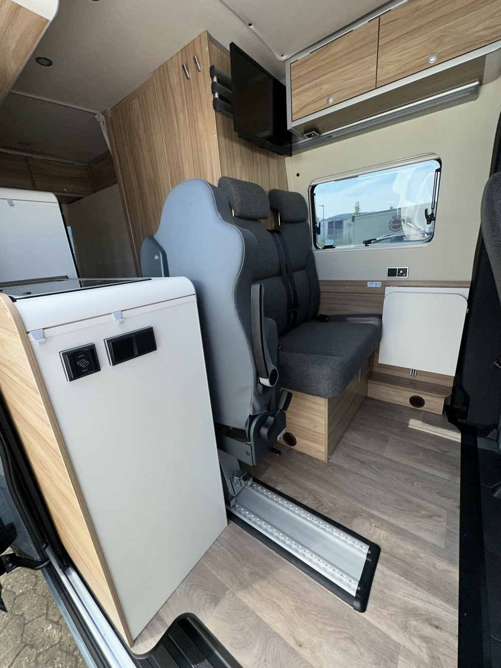 Wohnmobil-Innenraum mit nachgerüstetem Zusatzsitz und Einstiegsbereich